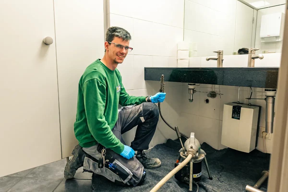 Besorgter Hausbesitzer spricht mit Techniker über Wasserschaden durch verstopftes Rohr