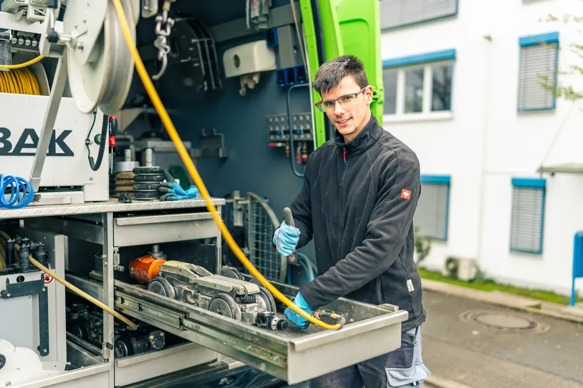Techniker reinigt eine Regenwasser-Zisterne im Garten
